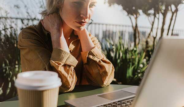 Woman sat at laptop with coffee