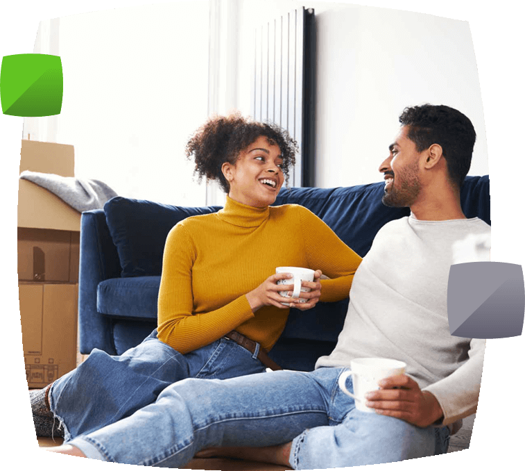 couple sitting on sofa surrounded by boxes