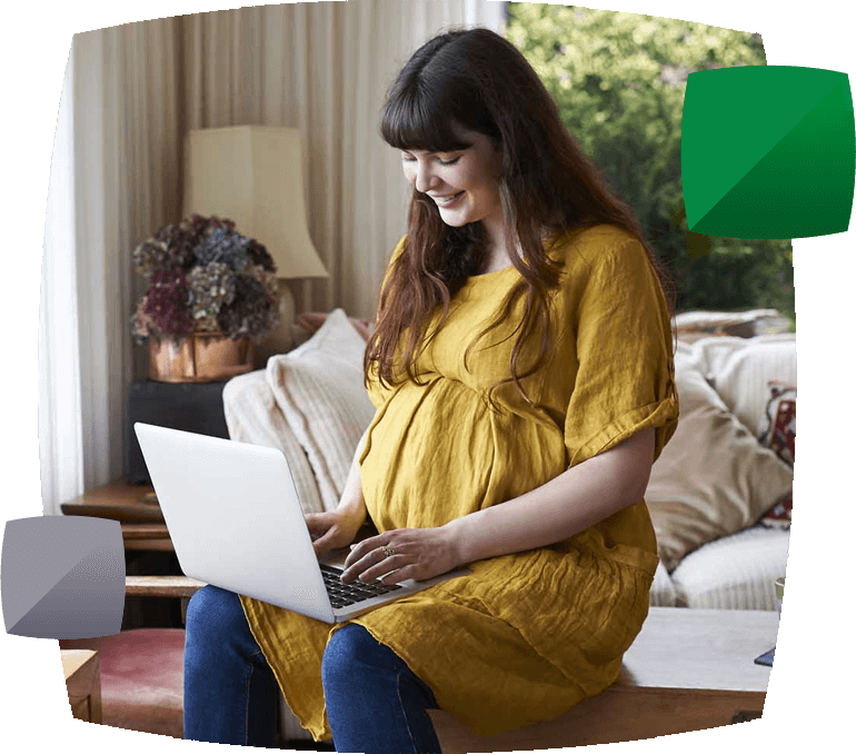 smiling pregnant woman on laptop