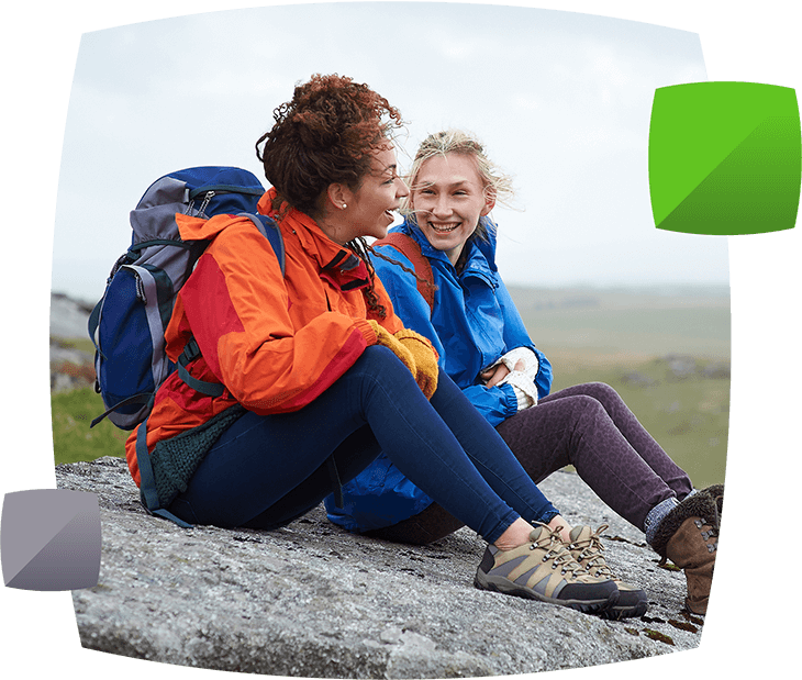 People smiling sitting on rock