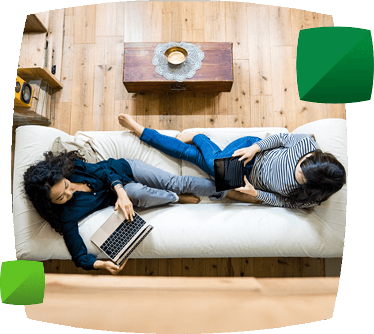 Women on sofa using technology